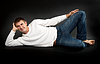 Mann im weißen Pullover liegend | Stock Foto