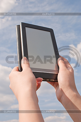 Hände halten elektronisches Buch Lesegerät gegen den blauen Himmel | Foto mit hoher Auflösung |ID 3163012